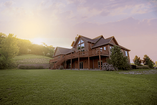 Red country home in a green field of grass | luxury homes by brittany corporation