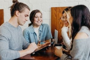 A group of friends at a coffee shop table with their iPads - Most expensive houses in the Philippines - Real estate sales professionals - Brittany Corporation - E-Suite Sellers Portal