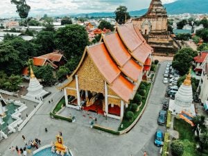 Chiang Mai Thailand best vegan travel destination building with orange high roof with tourists around the temple | luxury homes by brittany corporation