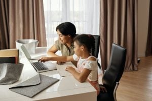 Mother helping daughter with online school learning | Luxury Homes by Brittany Corporation