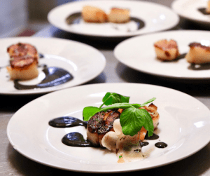 Perfectly grilled scallops with a wine reduction sauce topped with a sprigg of freshly picked basil a luxury house and lot dish for foodies | luxury homes by brittany corporation 
