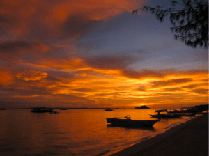 Photo of the sea and golden hour sky with boats by the shore in Western and Central Visayas where Cebuanos live - Brittany Corporation