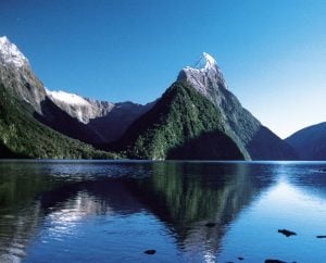 The lake and mountains of FIiordland National Park crystal clear waters and snow capped mountains give a picturesque view | Luxury Homes by Brittany Corporation