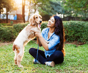 Woman playing with her blonde Cocker Spaniel in the park | Luxury Homes by Brittany Corporation