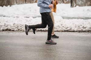 couple jogging for their heart health along a snowy path wearing black and khaki jogging pants luxury homes luxury house and lots by brittany corporation | Luxury homes by Brittany corporation