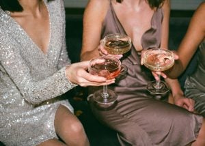 lady wearing silver dress and lady wearing brown metallic dress toast margaritas with an unseen thrird person in a party in a luxury homes by brittany corporation | luxury homes by brittany corporation