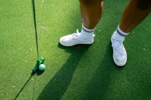 Green putter with a green golf ball | luxury homes by Brittany corporation