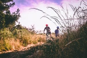 2 guys riding a bike while chatting | luxury homes by brittany corporation