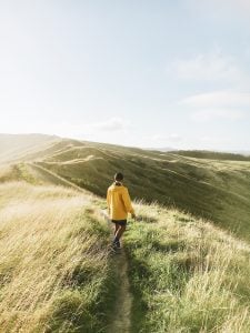 Back view of a man facing towards the footpath of a mountain | luxury homes by brittany corporation