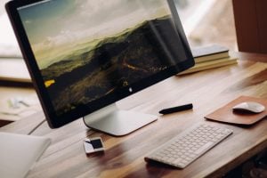 Photo of iMac on top of a wooden desk | Luxury Homes by Brittany Corporation 