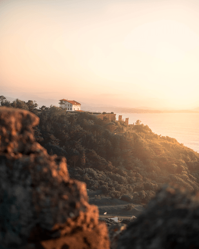 The setting sun shining on a hilltop house | Luxury Homes by Brittany Corporation