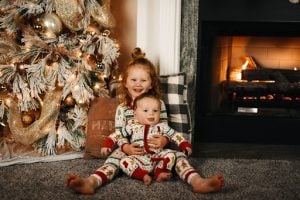 caucasian children in front of the christmas tree in their luxury home in brittany santa rosa | Luxury Homes by Brittany Corporation
