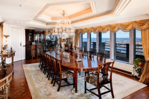 cityspire new york luxury condominium long wooden table and 8 chairs in the middle with a chandelier and white ceiling white carpet | Luxury Homes by Brittany Corporation