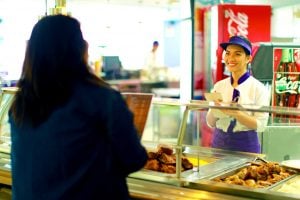 food server giving food to lady at enchanted kingdom near luxury homes in santa rosa laguna | Luxury Homes by Brittany corporation