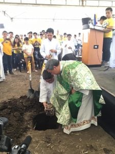 two priests bury a gilded box as people around them watch UST in Santa Rosa luxury homes | Luxury Homes by Brittany Corporation