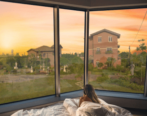 woman on bed overlooking portofino Alabang luxury house and lot properties | luxury homes by brittany corporation