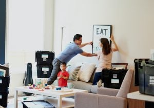 Photo of a couple hanging an artwork in a new house | Luxury homes by brittany corporation