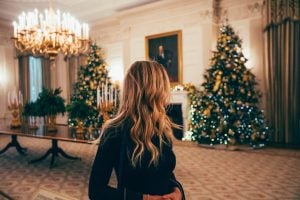 Photo of woman in black long sleeves, turning back on Christmas trees. | luxury homes by brittany corporation