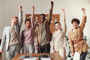 Team of young people raising their hands in the air. | luxury homes by brittany corporation