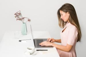 Woman typing on her laptop | luxury homes by brittany corporation
