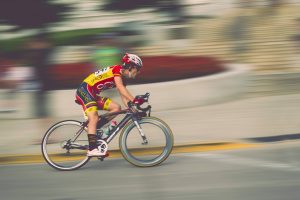 biking speeding through the streets in red and yellow gear | luxury homes by brittany corporation