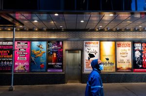 broadway with man in blue jacket in front of several award winning musicals | luxury homes by brittany corporation