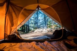 camping in the forest in a tent | luxury homes by brittany corporation