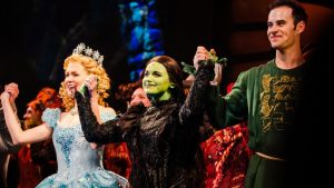 cast of wicked with glinda elphaba and fiyero holding hands | luxury homes by brittany corporation