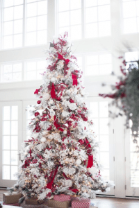 frosted red tree with red ribbons in luxury mansion | luxury homes by brittany corporation