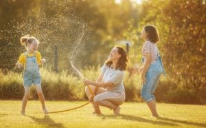 Happy family playing in backyard | luxury homes by brittany corporation