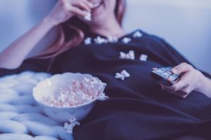 laady lounging on the bed with pop corn | luxury homes by brittany corporation