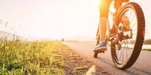 man on a bike on the side of the road facing the sun | luxury homes by brittany corporation