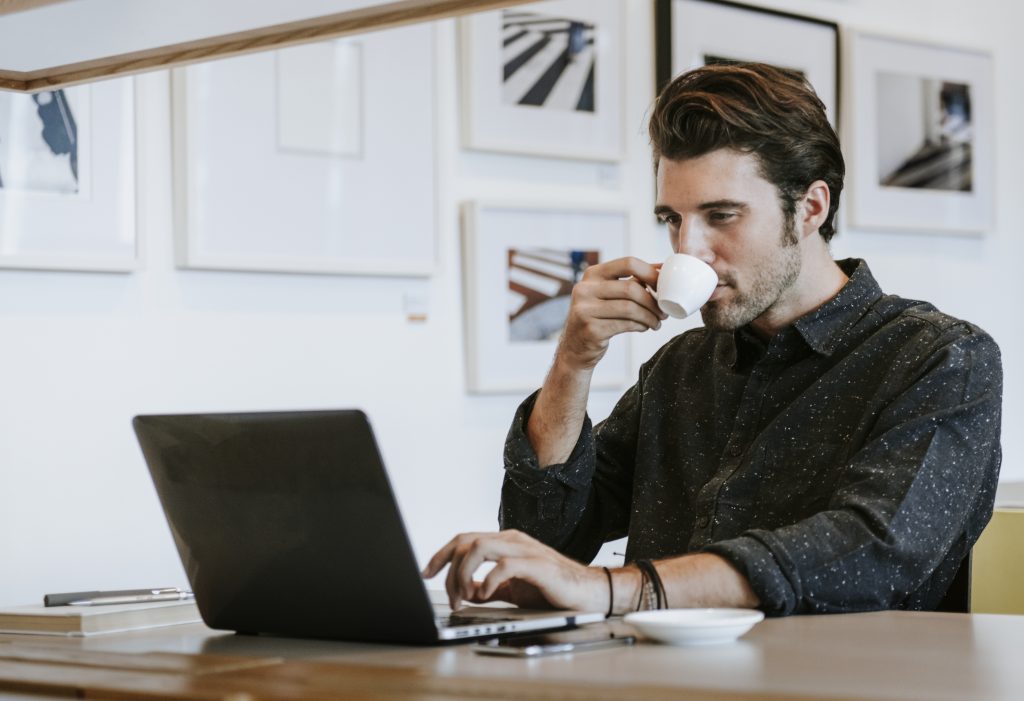 Man sipping a coffee while working | luxury homes by brittany corporation