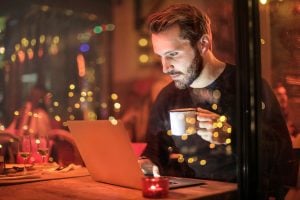 man watching on his laptop in a dark room | luxury homes by brittany corporation