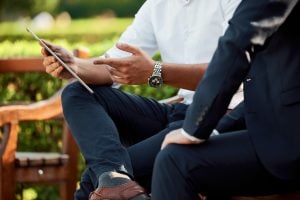 two businessmen having a meeting in the park | luxury homes by brittany corporation