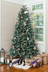 woodland style christmas tree in luxury home with gifts around it | luxury homes by brittany corporation