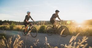 a couple riding their bike on the road | luxury homes by brittany corporation