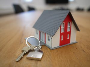 a house keychain on a wooden table | luxury homes by brittany corporation