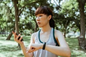 asian lady looking at her phone while holding her hand up | luxury homes by brittany corporation