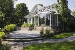 Brick and stone cottage style home with sunroom, patio and landscaped backyard, Quebec, Canada | luxury homes by brittany corporation