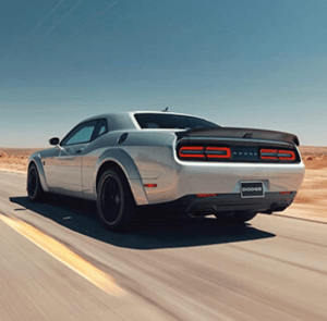 dodge challenger car on the high way | luxury homes by brittany corporation