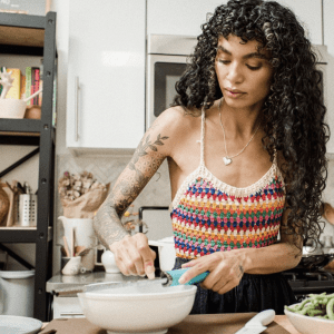 lady adding garlic to dish with big curls | luxury homes by brittany corporation
