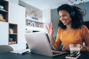 lady with curly hair looking at laptop | luxury homes by brittany corporation