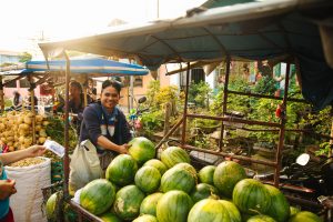 man smiling to the camera as he holds a watermelon | luxury homes by brittany corporation