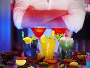 man with crossed arms in from of colorful cocktails | luxury homes by brittany corporation