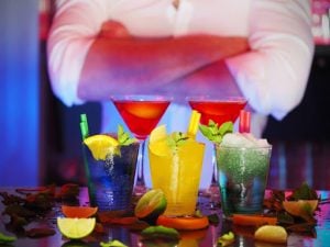 man with crossed arms in from of colorful cocktails | luxury homes by brittany corporation