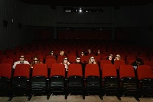 theater goers watching a film with social distancing | luxury homes by brittany corporation