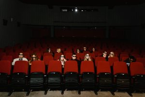 theater goers watching a film with social distancing | luxury homes by brittany corporation