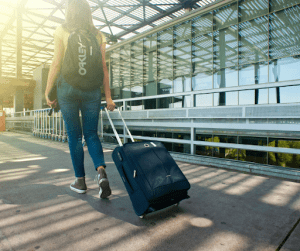 woman holding a bag on the way to the airplane | luxury homes by brittany corporation