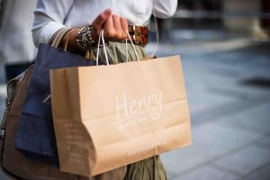 woman holding a brown bag with the word henry on it | luxury homes by brittany corporation